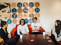 Four students sitting around a table talking