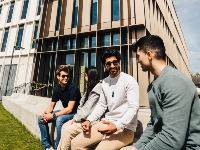 students sat outside a building on campus