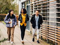 three students walking outside on campus