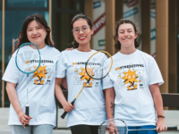 Three students holding badminton rackets