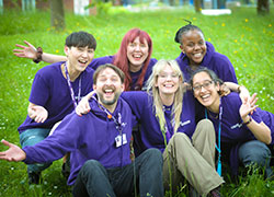 Warwick presents team members sitting on the ground