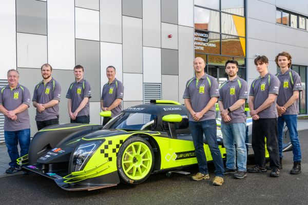 Men standing beside race car