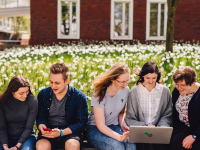 students sat outside on bench in summer