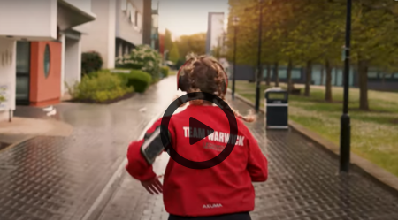 person running on sidewalk with playbutton cover