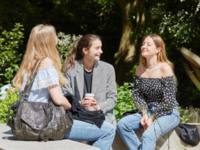 group of 3 students sat outside