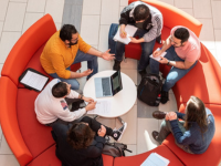 students on a soft seating sofa with laptops from a birds eye view