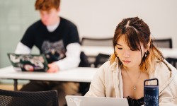 Two students working on laptops